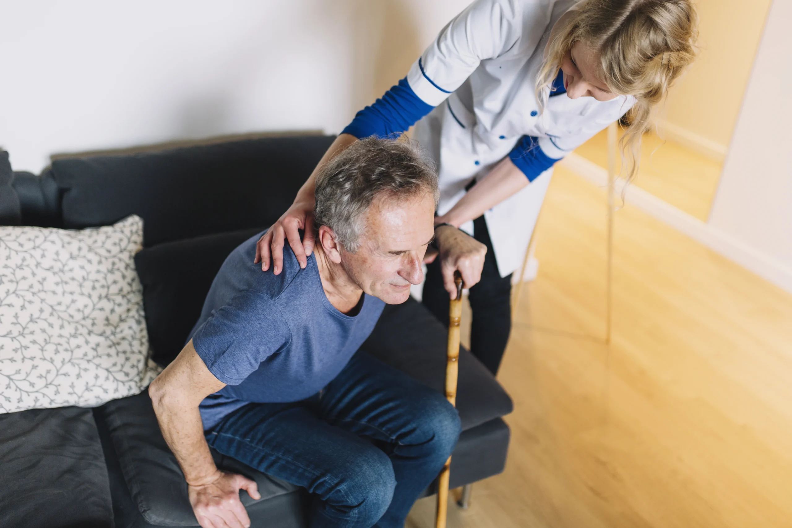 An aged man getting physiotherapy for his lower back from an female therapist